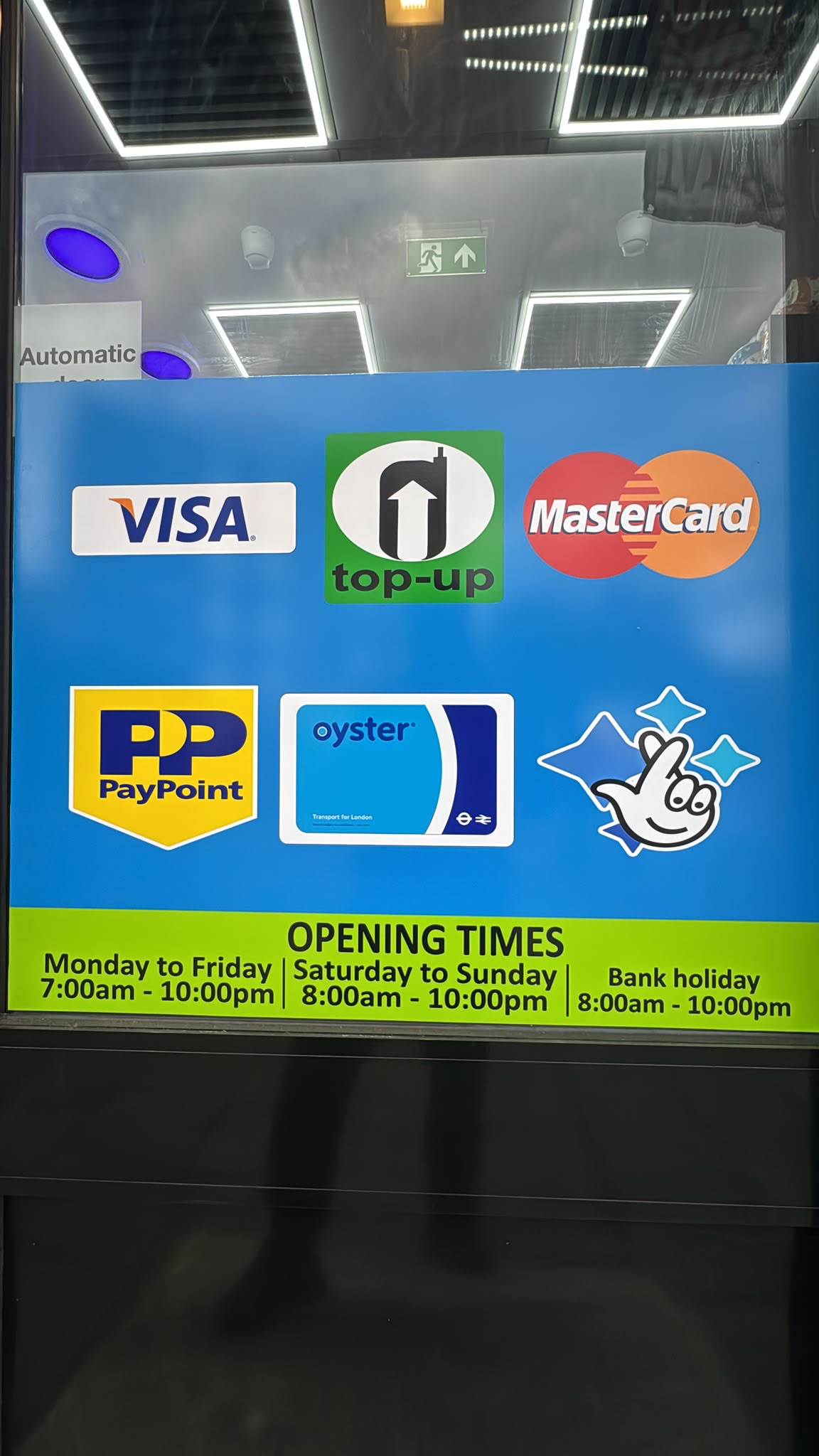 Window sign showing accepted payments and opening times